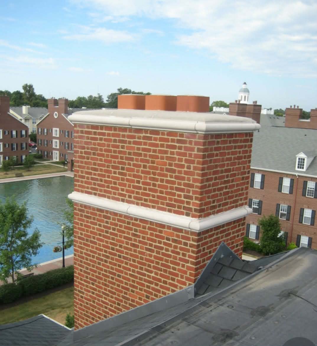 Professional brick chimney masonry restoration with precision tuckpointing and new concrete cap.