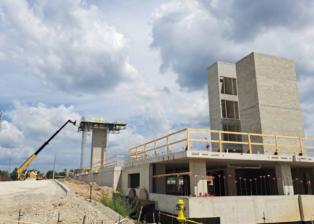 Wide view of a commercial site showcasing concrete block masonry Indianapolis structural construction with heavy machinery.